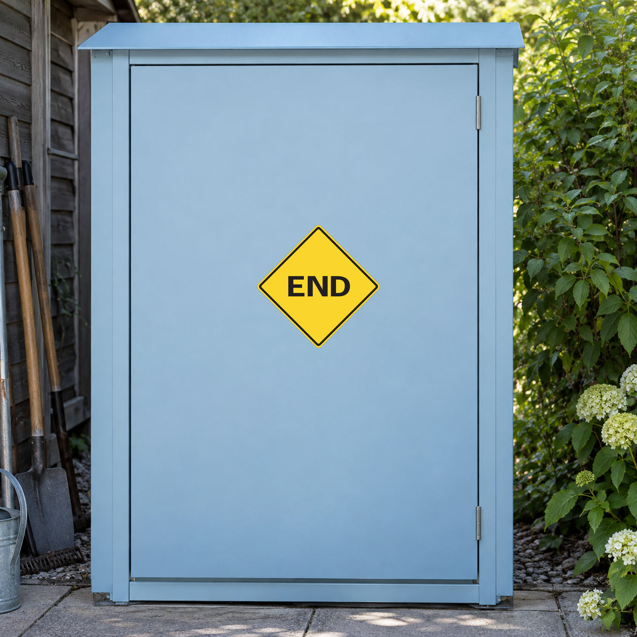 Road Sign Sticker applied in A pale blue rural property maintenance cupboard with path tools extreme left and garden greenery far right, single smooth blank door