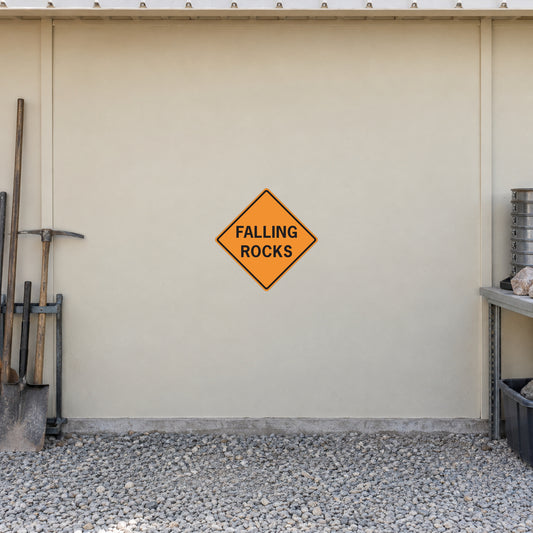 Road Sign Sticker applied in A pale cream quarry maintenance shed smooth wall with rock sampling tools extreme left and gravel floor below, blank central surface