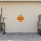 Road sign warning sticker with yellow diamond and black text: “FALLING ROCKS”