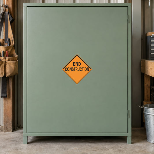 Road Sign Sticker applied in A sage green contractor workshop smooth cupboard with toolbelt extreme left and bucket low right, blank central front
