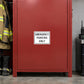 Road Sign Sticker applied in A muted red first responder equipment locker beside boots low left and radio charger at extreme right, blank smooth single front