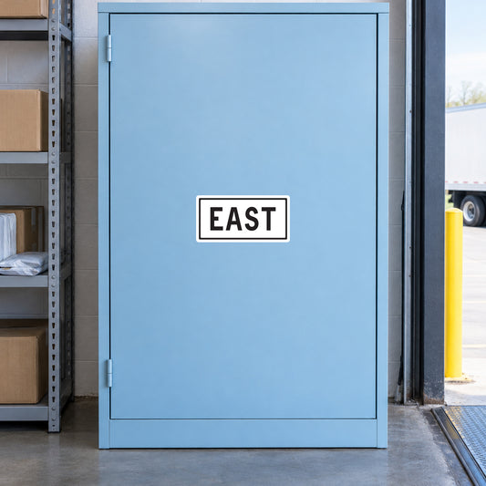 Road Sign Sticker applied in A pale blue logistics receiving office storage cupboard with parcel shelf extreme left and dock edge far right, blank single smooth door