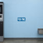 Road Sign Sticker applied in A pale blue parking office wall with ticket machine extreme left and coin tray low right, blank smooth center