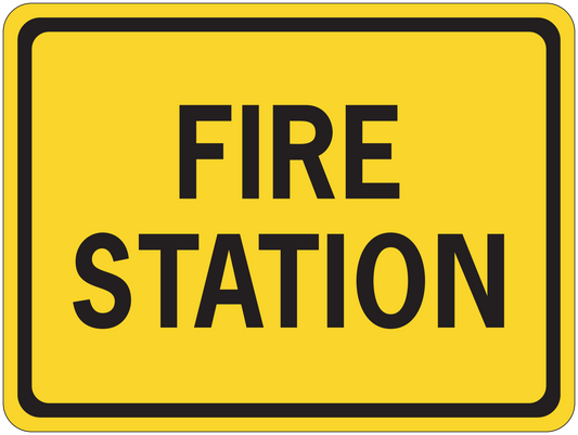Road sign sticker with yellow background and black border, text "FIRE STATION".