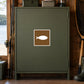 Road Sign Sticker applied in A moss green lakeside tackle room cupboard with fishing reel edge left and landing net extreme right, blank smooth single door