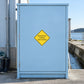 Road Sign Sticker applied in A pale blue waterside service depot cabinet with rubber boots low left and drainage ditch far right, broad blank smooth door