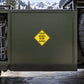 Road Sign Sticker applied in A dark olive mountain service garage cupboard with snow chains far left and vehicle tyre far right, blank smooth front