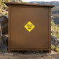 Landslide hazard area warning sticker on road sign panel, yellow diamond with black text