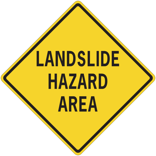 Yellow road sign sticker, black border diamond reading “LANDSLIDE HAZARD AREA”