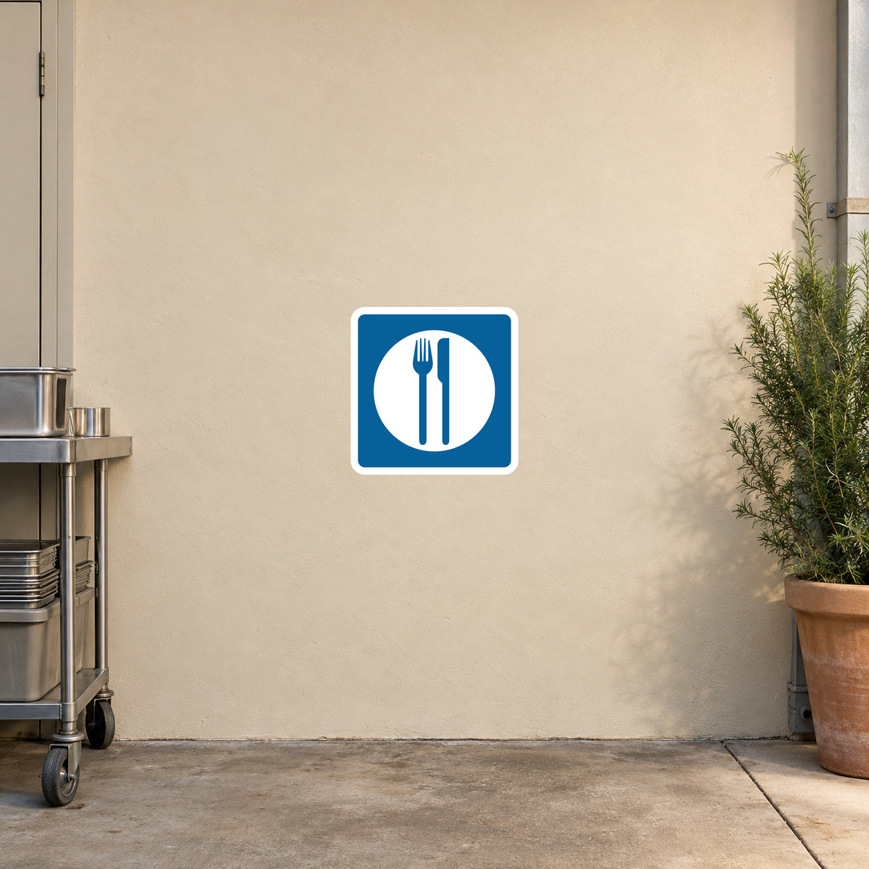 Road Sign Sticker applied in A highway cafe back entrance, uninterrupted warm ivory plaster wall, stainless prep trolley extreme left and potted rosemary extreme right