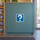 Road Sign Sticker applied in A visitor information office foyer, single smooth muted teal cupboard door, map rack extreme left without visible writing and floor mat below