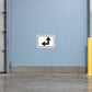 Road Sign Sticker applied in A distribution center junction corridor, smooth pale blue wall, yellow protective post far right and clean concrete below