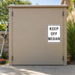 Road Sign Sticker applied in A landscaped campus maintenance shed, smooth tan cabinet front, lawn edging tool extreme left and grasses extreme right
