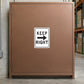 Road Sign Sticker applied in A distribution warehouse service entry, single muted copper steel cupboard panel, cartons far right