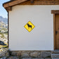 Road Sign Sticker applied in A mountain wildlife ranger hut, uninterrupted warm white plaster wall, rocky landscape sliver extreme left