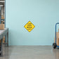 Road Sign Sticker applied in A logistics sorting facility, uninterrupted pale aqua concrete wall, parcel dolly far right