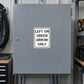 Road Sign Sticker applied in A traffic signal repair workshop, smooth medium grey single cabinet door, cable coils extreme left