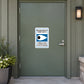 Road Sign Sticker applied in A neighborhood community hall entrance, smooth muted green metal door, handle far right and flowerpot extreme left