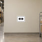 Road Sign Sticker applied in A warehouse corridor intersection, uninterrupted pale sand plaster wall, rolling supply cart extreme right