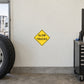 Road sign sticker with yellow diamond “SLOW TRUCKS” warning text