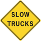 Yellow road sign sticker with black "SLOW TRUCKS" text, diamond shape