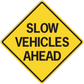 Road sign sticker with yellow diamond and text SLOW VEHICLES AHEAD