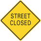 Yellow road sign sticker with black border reading "STREET CLOSED"