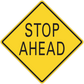 Road sign sticker: yellow diamond with black border reading 'STOP AHEAD'.