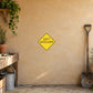 Road Sign Sticker applied in A rural groundskeeper workshop, uninterrupted warm sand plaster wall, shovel far right
