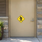 Yellow pedestrian crossing road sign sticker with black walking person inside a diamond