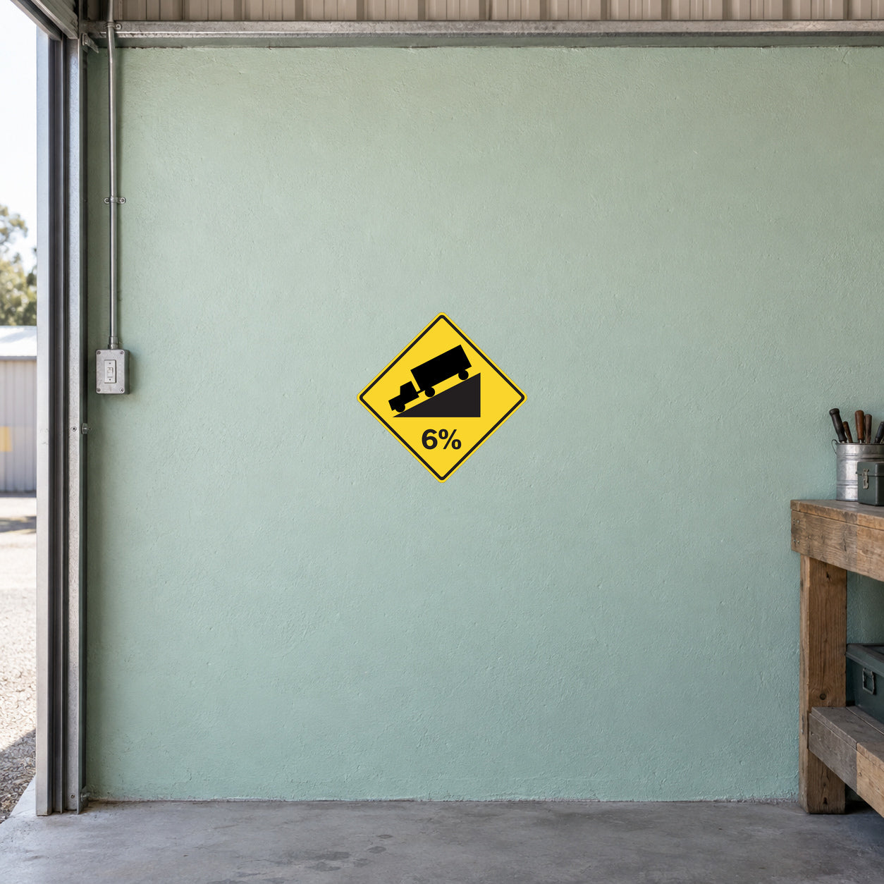 Road Sign Sticker applied in A rural freight shed, uninterrupted pale mint concrete wall, workbench edge far right