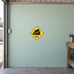 Road Sign Sticker applied in A rural freight shed, uninterrupted pale mint concrete wall, workbench edge far right