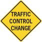 Yellow road sign sticker with black border reading "TRAFFIC CONTROL CHANGE"