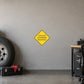 Road Sign Sticker applied in A trucking dispatch workshop, uninterrupted warm grey plaster wall, large wheel far left