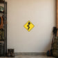Road Sign Sticker applied in A mountain road equipment storage room, uninterrupted warm cream plaster wall, chain rack far left