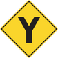 Yellow road sign sticker with black downward arrow in diamond