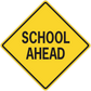 Yellow road sign sticker, black-bordered diamond reading SCHOOL AHEAD