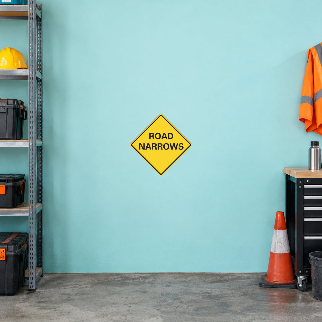 Road Sign Sticker applied in A roadworks equipment garage, uninterrupted pale aqua wall, folded orange vest far right