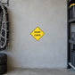 Yellow road sign sticker with black “SHARP CURVE” text in a diamond shape