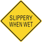 Road sign sticker with yellow diamond and black border, text “SLIPPERY WHEN WET”