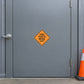 Road Sign Sticker applied in A public works traffic store, smooth slate grey steel door, handle far left and orange cone far right