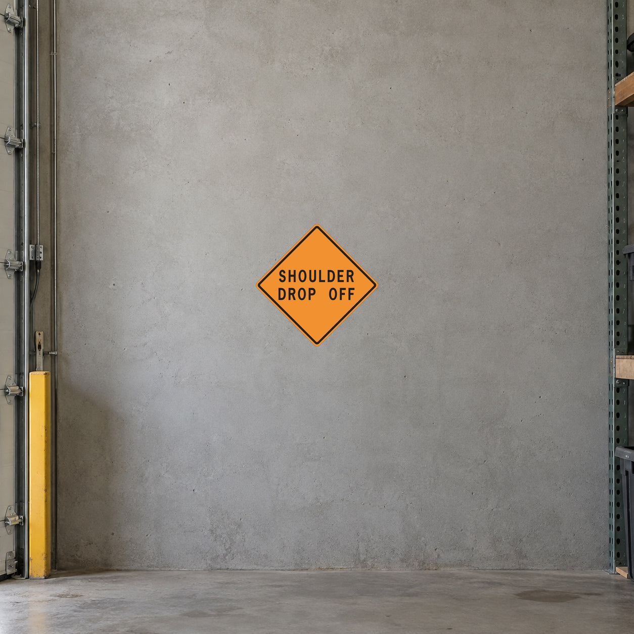 Road Sign Sticker applied in A civil contractor storage bay, uninterrupted warm grey concrete wall, barrier folded far left