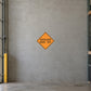 Road Sign Sticker applied in A civil contractor storage bay, uninterrupted warm grey concrete wall, barrier folded far left