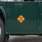 Yellow diamond warning sticker reading "WATCH FOR TRUCKS"