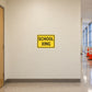 Road Sign Sticker applied in a continuous warm cream school service corridor wall with safety cones at far right