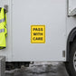 Yellow road sign sticker with black text: PASS WITH CARE.