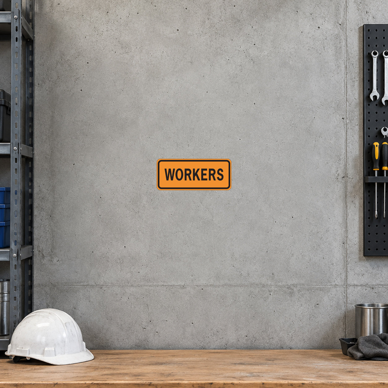 Road Sign Sticker applied in a continuous pale grey concrete tool room wall, hard hat on bench at far bottom edge