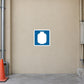 Road Sign Sticker applied in a continuous light tan industrial service passage wall with orange cone and pipework only at far edges