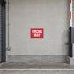 Road Sign Sticker applied in a continuous light grey painted concrete wall at a private parking garage service entrance, barrier mechanism only far right