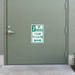 Road Sign Sticker applied in a smooth sage parking service entrance door, handle at far left edge and paved ground below